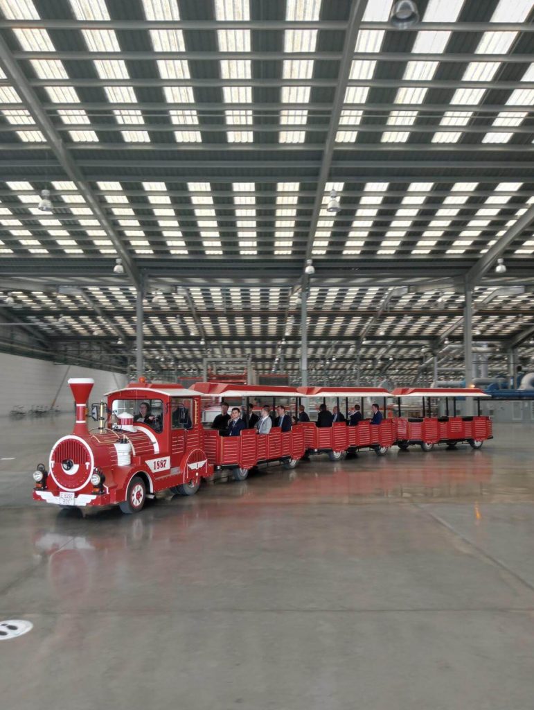 Tren turístico circulando por el interior de una fábrica